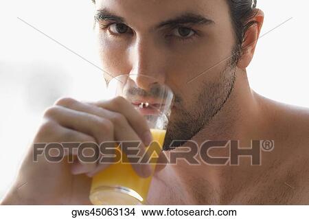 Close-up of a young man drinking a glass of juice View Large Photo Image Picture - Close-up of a young man drinking a glass of juice. Fotosearch