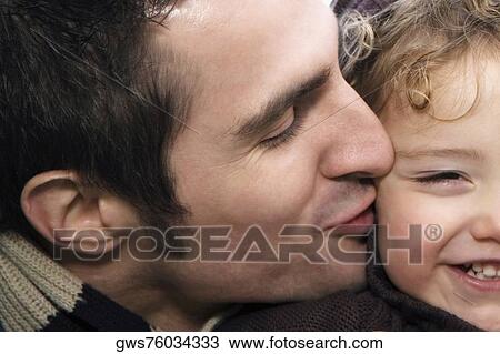 Close-up of a young man kissing his daughter View Large Photo Image Stock Image - Close-up of a young man kissing his daughter. Fotosearch