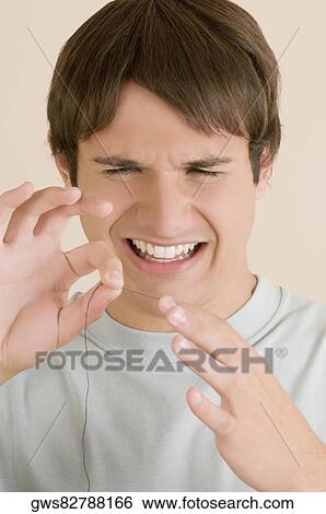 Close-up of a young man pinching a needle in his finger View Large Photo Image Stock Photograph - Close-up of a young man pinching a needle in his finger. Fotosearch