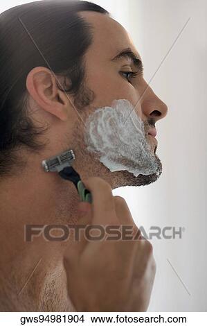 Close-up of a young man shaving with a razor View Large Photo Image Picture - Close-up of a young man shaving with a razor. Fotosearch