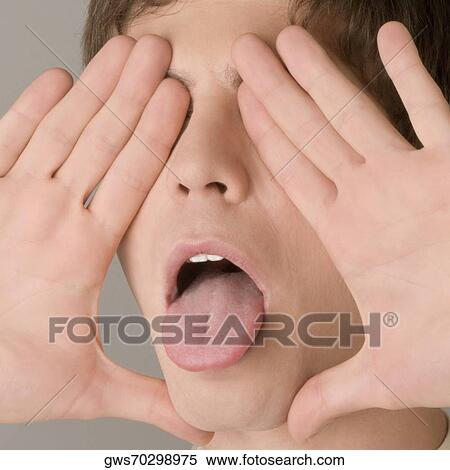 Stock Photography - Close-up of a young man sticking his tongue out. Fotosearch