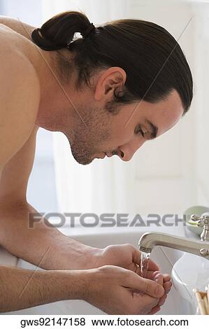 Close-up of a young man washing his face View Large Photo Image Stock Photo - Close-up of a young man washing his face. Fotosearch