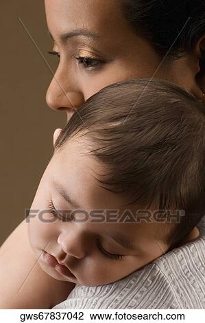 Close-up of a young woman carrying her son View Large Photo Image Stock Image - Close-up of a young woman carrying her son. Fotosearch