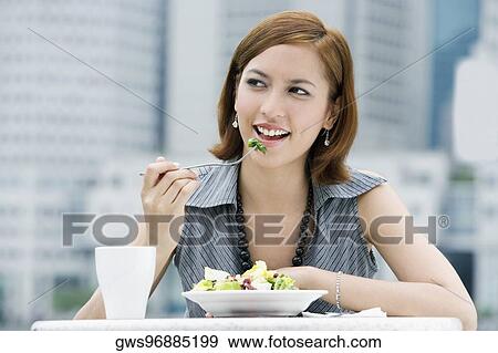 Stock Photo - Close-up of a young woman eating salad. Fotosearch