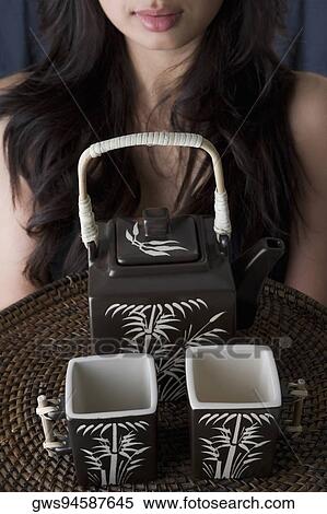 Close-up of a young woman holding a tray of two tea cups and a kettle View Large Photo Image Stock Photography - Close-up of a young woman holding a tray of two tea cups and a kettle. Fotosearch