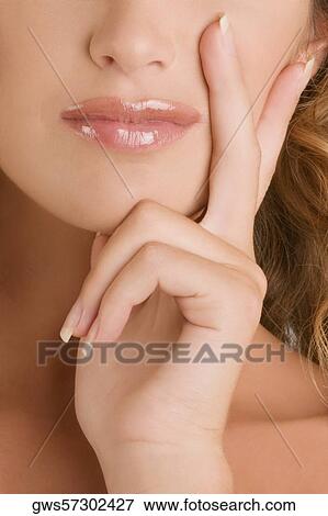 Stock Photo - Close-up of a young woman with her hand on her chin. Fotosearch