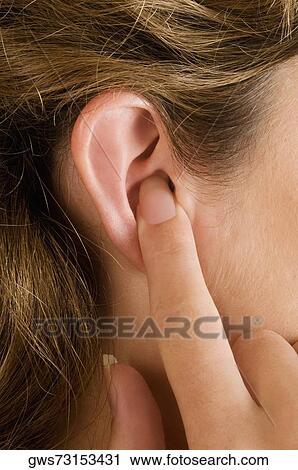 Close-up of a young woman's finger in her ear View Large Photo Image Stock Image - Close-up of a young woman's finger in her ear. Fotosearch