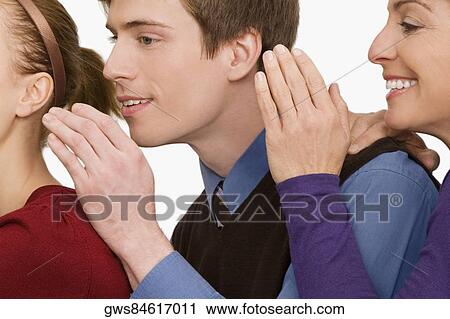 Stock Image - Close-up of business executives whispering to each other. Fotosearch