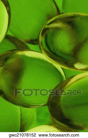Stock Image - Close-up of green capsules. Fotosearch