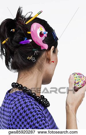 Stock Photo - Close-up of office supply items in a young woman's hair. Fotosearch