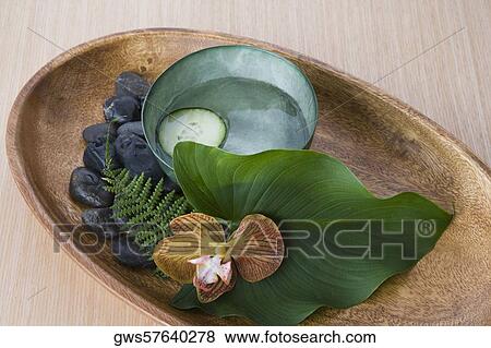 Stock Photo - Close-up of pebbles with leaf and herbs in a tray. Fotosearch