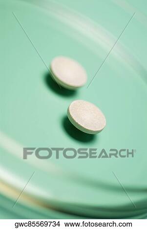 Picture - Close-up of two pills in a petri dish. Fotosearch