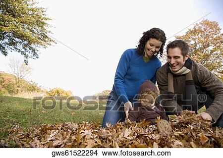Couple and their daughter playing with leaves View Large Photo Image Picture - Couple and their daughter playing with leaves. Fotosearch