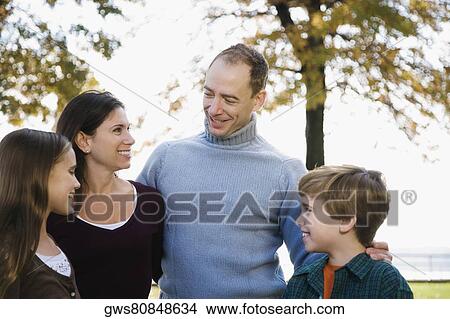Picture - Couple and their two children standing together and smiling. Fotosearch