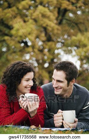 Stock Photo - Couple having coffee in a lawn. Fotosearch