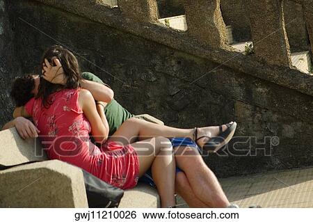 Couple sitting on a bench and kissing each other, Biarritz, Basque Country, Pyrenees-Atlantiques, Aquitaine, France View Large Photo Image Stock Photograph - Couple sitting on a bench and kissing each other, Biarritz, Basque Country, Pyrenees-Atlantiques, Aquitaine, France. Fotosearch