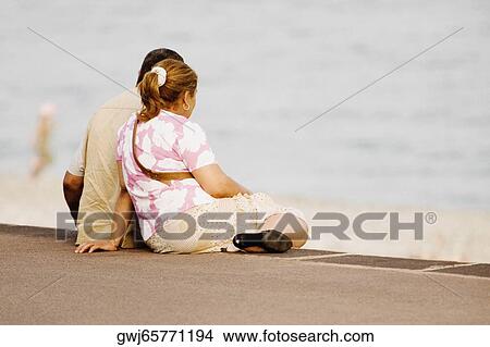 Picture - Couple sitting on the beach, Promenade Des Anglais, Nice, Provence-Alpes-Cote D'Azur, France. Fotosearch