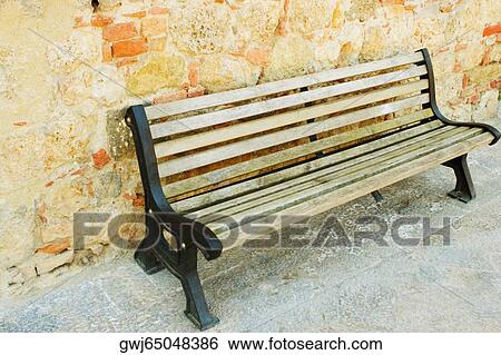 Stock Photograph - Empty bench in front of a wall, Monteriggioni, Siena Province, Tuscany, Italy. Fotosearch