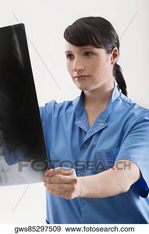 Female doctor examining an X-Ray report View Large Photo Image Stock Photo - Female doctor examining an X-Ray report. Fotosearch