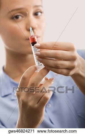 Female doctor holding a syringe View Large Photo Image Stock Image - Female doctor holding a syringe. Fotosearch