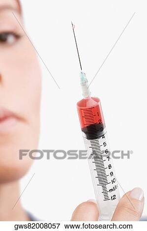 Female doctor holding a syringe View Large Photo Image Stock Photo - Female doctor holding a syringe. Fotosearch