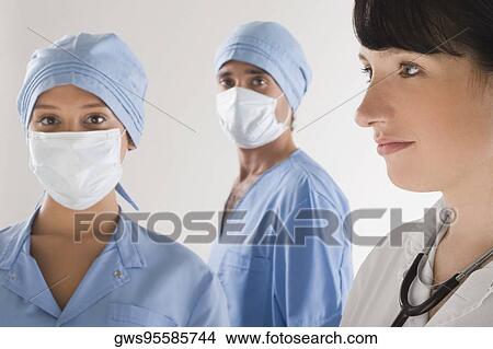 Female doctor with two surgeons View Large Photo Image Picture - Female doctor with two surgeons. Fotosearch