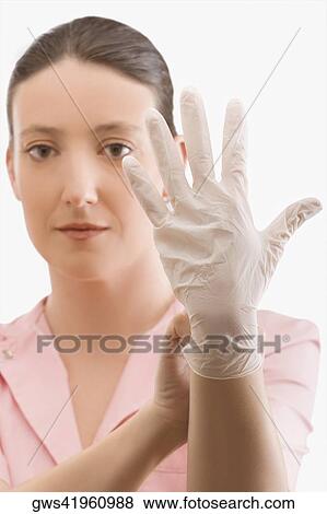Female nurse putting on a surgical glove View Large Photo Image Stock Photo - Female nurse putting on a surgical glove. Fotosearch