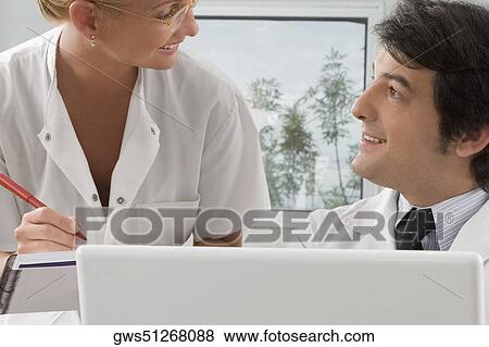 Female nurse talking to a male doctor View Large Photo Image Stock Photo - Female nurse talking to a male doctor. Fotosearch