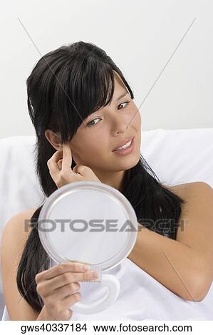 Female patient examining her face in a mirror View Large Photo Image Picture - Female patient examining her face in a mirror. Fotosearch