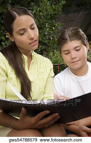 Female teacher checking the file of a schoolgirl View Large Photo Image Stock Photo - Female teacher checking the file of a schoolgirl. Fotosearch