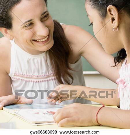 Female teacher teaching her student in a classroom View Large Photo Image Stock Photo - Female teacher teaching her student in a classroom. Fotosearch
