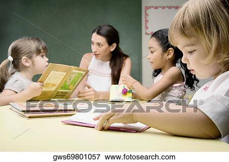 Female teacher teaching her students in a classroom View Large Photo Image Stock Photo - Female teacher teaching her students in a classroom. Fotosearch