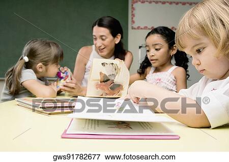 Female teacher teaching her students in a classroom View Large Photo Image Stock Photo - Female teacher teaching her students in a classroom. Fotosearch