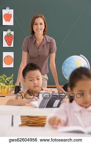 Female teacher teaching her students in a classroom View Large Photo Image Stock Photograph - Female teacher teaching her students in a classroom. Fotosearch