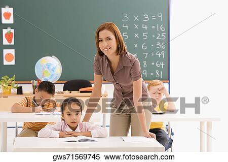 Female teacher teaching her students in a classroom View Large Photo Image Stock Photography - Female teacher teaching her students in a classroom. Fotosearch