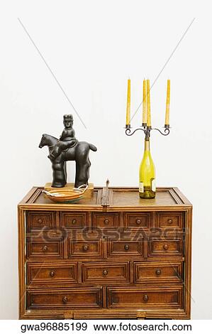 Figurine and a candlestick holder on a chest View Large Photo Image Stock Photo - Figurine and a candlestick holder on a chest. Fotosearch