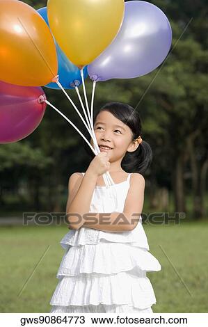 Girl holding balloons and smiling View Large Photo Image Stock Image - Girl holding balloons and smiling. Fotosearch