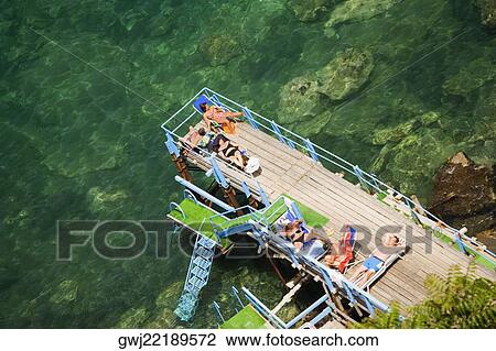 Group of people resting at seaside, Bay of Naples, Sorrento, Naples Province, Campania, Italy View Large Photo Image Stock Image - Group of people resting at seaside, Bay of Naples, Sorrento, Naples Province, Campania, Italy. Fotosearch