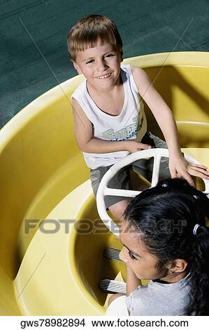 High angle view of a boy and a girl in a toy car View Large Photo Image Picture - High angle view of a boy and a girl in a toy car. Fotosearch