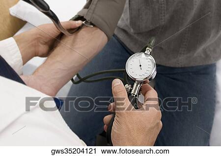High angle view of a doctor checking a patient's blood pressure View Large Photo Image Stock Image - High angle view of a doctor checking a patient's blood pressure. Fotosearch