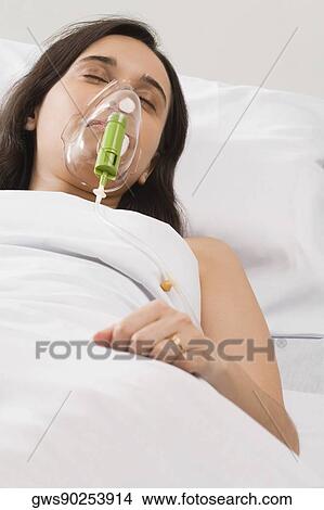 High angle view of a female patient wearing an oxygen mask View Large Photo Image Picture - High angle view of a female patient wearing an oxygen mask. Fotosearch