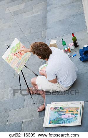 High angle view of a man painting on an easel, Italian Riviera, Genoa, Liguria, Italy View Large Photo Image Stock Photo - High angle view of a man painting on an easel, Italian Riviera, Genoa, Liguria, Italy. Fotosearch