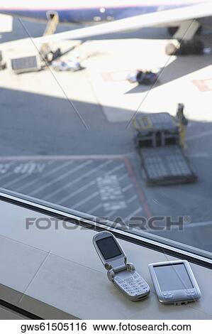 Stock Photograph - High angle view of a mobile phone and a personal data assistant. Fotosearch