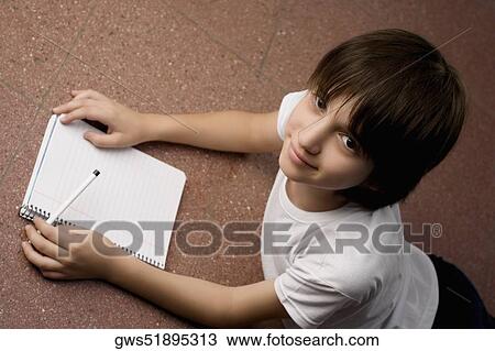 Stock Image - High angle view of a schoolboy smiling. Fotosearch