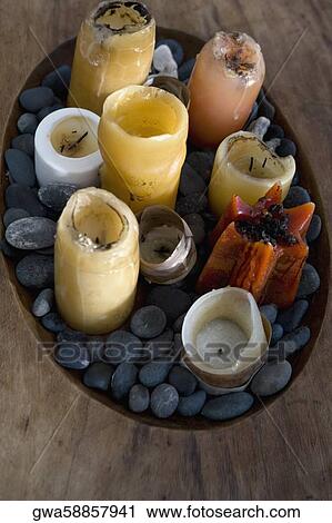 Stock Image - High angle view of candles and pebbles in a wooden tray. Fotosearch
