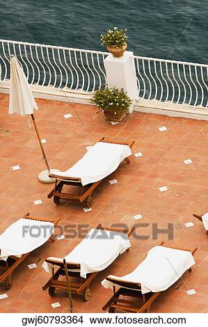 High angle view of empty lounge chairs with a patio umbrella, Positano, Amalfi Coast, Salerno, Campania, Italy View Large Photo Image Picture - High angle view of empty lounge chairs with a patio umbrella, Positano, Amalfi Coast, Salerno, Campania, Italy. Fotosearch