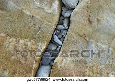High angle view of pebbles in a gap of rocks View Large Photo Image Picture - High angle view of pebbles in a gap of rocks. Fotosearch