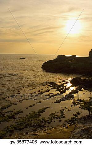 Stock Photograph - High angle view of rocks in the sea at dusk, Biarritz, Basque Country, Pyrenees-Atlantiques, Aquitaine, France. Fotosearch