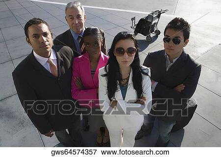 High angle view of two businesswomen standing with three businessmen at an airport View Large Photo Image Stock Photo - High angle view of two businesswomen standing with three businessmen at an airport. Fotosearch