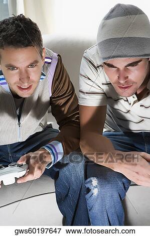 High angle view of two young men playing video game View Large Photo Image Stock Photo - High angle view of two young men playing video game. Fotosearch